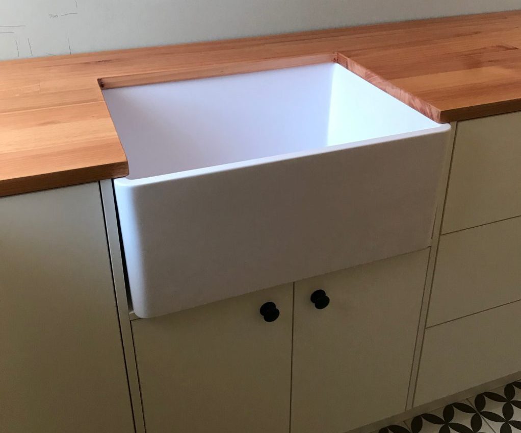large ceramic laundry sink embedded in warm timber benchtop